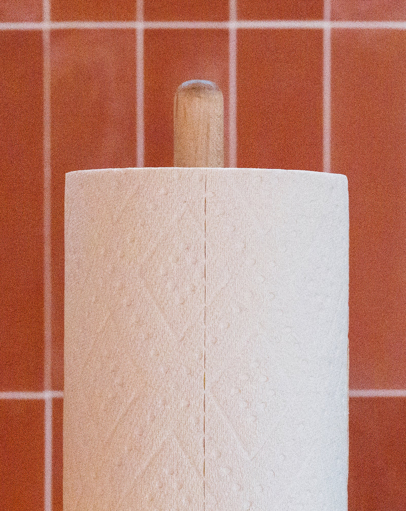 Close-up of a PlantPaper Towel roll showcasing thick white sheets against terracotta tile